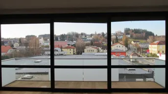 Heller Wohnraum mit großen Schiebetüren und weitem Blick über die Stadt und die Umgebung.