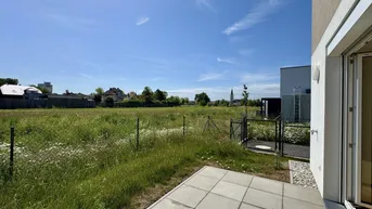 Weitläufiger, unberührter Gartenbereich mit Blick auf die umliegende Landschaft und Gebäude.