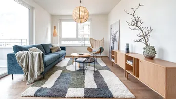 Helles Wohnzimmer mit modernem Teppich, bequemer Couch und Zugang zum Balkon.