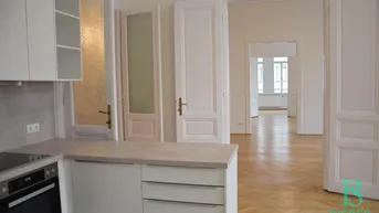 Teilansicht einer modernen Küche mit Arbeitsplatte und Blick in angrenzende Räume.