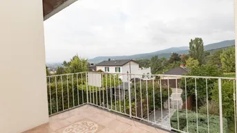 Geräumiger Balkon mit Fliesenboden und Blick auf die grüne Umgebung und die Berge.