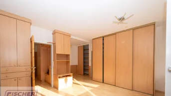 Geräumiges Schlafzimmer mit Einbauschränken und hellem Laminatboden, bietet viel Stauraum.