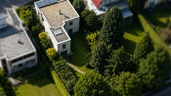Luftaufnahme des Hauses mit Flachdach, Solaranlage und großem, gepflegtem Gartenbereich.