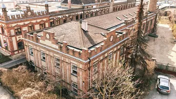 Historisches Backsteingebäude mit markanter Architektur und Satteldach aus der Vogelperspektive.