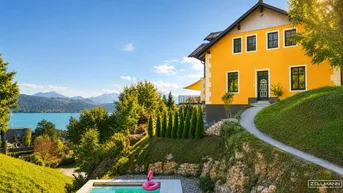 Gelbes Haus mit Pool, gepflegtem Garten und Panoramablick auf See und Berge unter blauem Himmel.
