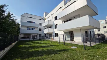 Außenansicht eines modernen Wohngebäudes mit gepflegtem Rasen und Balkonen.