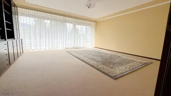 Geräumiges Schlafzimmer mit Teppichboden, großen Fenstern und Einbauschränken.