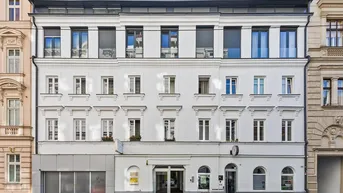 Moderne Fassade eines Wohngebäudes mit großen Fenstern und Rollläden in der Stadt.