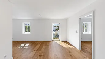 Heller Wohnbereich mit neuem Parkettboden, weißen Wänden und Zugang zu einem französischen Balkon.
