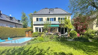 Großzügiger Garten mit Swimmingpool, Rasenfläche, altem Baumbestand und einer sonnigen Terrasse am Haus.