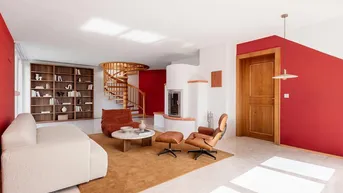 Geräumiges Wohnzimmer mit roter Akzentwand, Kamin und eleganter Wendeltreppe aus Holz.