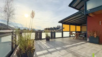 Weitläufige Sonnenterrasse mit Bergblick und überdachtem Bereich, ideal zum Entspannen.