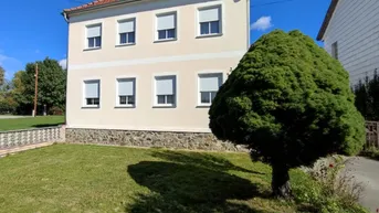 Klassisches Einfamilienhaus mit heller Fassade, Rollläden und gepflegtem Vorgarten.