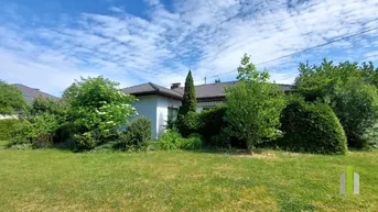 Weitläufiger Gartenbereich mit gepflegtem Rasen und üppiger Bepflanzung rund um das Haus.