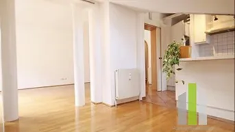 Helles Wohnzimmer mit Holzboden und offenem Übergang zu anderen Bereichen, ausgestattet mit Heizkörper.