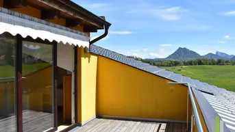 Geräumiger Balkon mit Holzboden und weitem Blick auf die umliegende Berglandschaft.