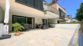 Große, sonnige Terrasse mit modernen Fliesen und bequemen Outdoor-Möbeln, ideal zum Entspannen.