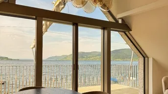 Moderner Essbereich mit großem Esstisch, stilvoller Deckenleuchte und atemberaubendem Seeblick durch große Fenster.