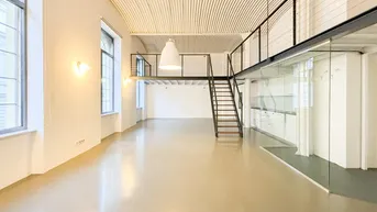 Heller, offener Loft-Wohnbereich mit gewölbter Decke und Blick auf die Stadt durch große Fenster.