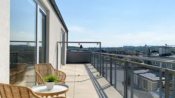 Geräumiger Balkon mit Sitzgelegenheiten und weitem Blick über die Stadt und grüne Hügel.