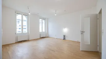 Helles, leeres Zimmer mit Parkettboden und zwei großen Fenstern, bereit zur individuellen Gestaltung.