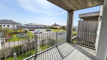 Geräumiger Balkon mit Fliesenboden und Blick auf die umliegende Wohngegend und Grünflächen.