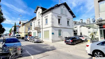 Historisches Gebäude mit klassischer Architektur und gepflegter Fassade an einer belebten Straße.