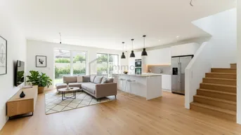 Helles, offenes Wohnzimmer mit integrierter Küche, Holzboden und Zugang zum Garten.
