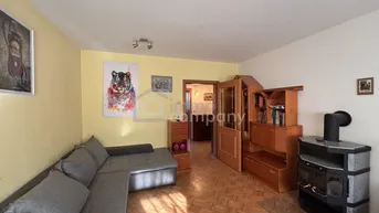Gemütliches Wohnzimmer mit Parkettboden, Ecksofa und einem Kaminofen für wohlige Wärme.