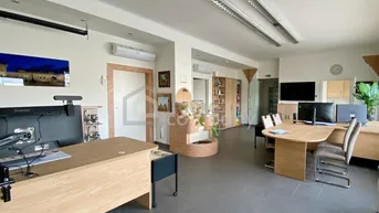 Geräumiges Büro mit mehreren Arbeitsplätzen, dunklen Fliesen und Klimaanlage für ein angenehmes Raumklima.