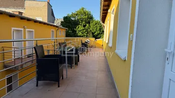 Geräumige Terrasse mit Fliesenboden und Sitzgelegenheiten, ideal für entspannte Stunden im Freien mit Grünblick.