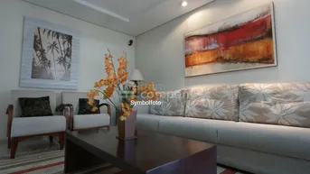 Helles Wohnzimmer mit bequemen Sofas, einem Couchtisch und moderner Kunst an den Wänden.
