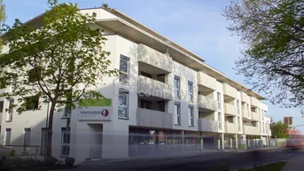 Modernes Mehrfamilienhaus mit Balkonen und großen Fenstern an einer städtischen Straße gelegen.