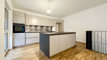 Moderne Einbauküche mit Kücheninsel, integrierten Geräten und hellem Parkettboden.