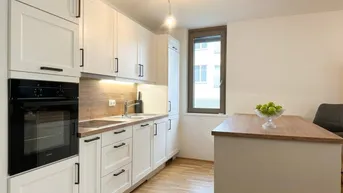 Moderne Einbauküche mit weißen Schränken, Holzarbeitsplatte und integrierten Geräten, ideal für den täglichen Gebrauch.