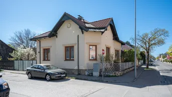 Ansicht des charmanten Einfamilienhauses von der Straßenecke mit gepflegter Fassade und Fenstern.