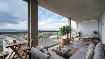 Geräumiger Balkon mit gemütlicher Sitzecke und weitem Blick über die Stadt und Landschaft.