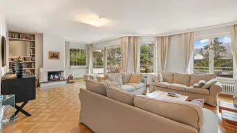 Geräumiges Wohnzimmer mit Parkettboden, Kamin und Zugang zu einer großen Terrasse mit Bergblick.