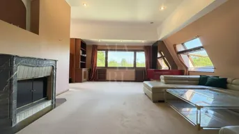 Großzügiges Wohnzimmer mit Kamin, Teppichboden und beiger Ledercouch.
