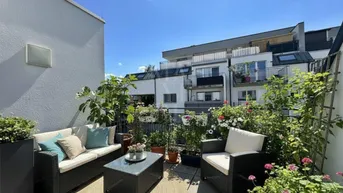 Geräumige Sonnenterrasse mit bequemen Gartenmöbeln und üppiger Bepflanzung, ideal zum Entspannen im Freien.