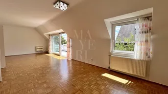Helles Wohnzimmer mit Parkettboden, Dachschrägen und Zugang zur Terrasse.