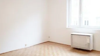 Helles, leeres Zimmer mit Parkettboden und großem Fenster, bereit zur individuellen Gestaltung.