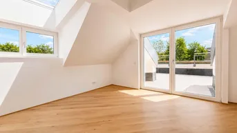 Heller Dachgeschossraum mit Holzboden, Dachfenstern und Blick ins Grüne von der Terrasse.