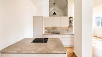 Moderne Küche mit Kücheninsel, Induktionskochfeld und hohen Decken in einem hellen Raum.