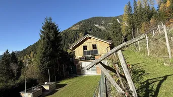 Charmantes Holzhaus in Hanglage mit Photovoltaikanlage und weitem Blick auf die Berge.