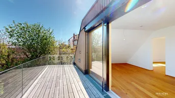 Geräumige Holzterrasse mit Glasgeländer und Zugang zu einem hellen Innenraum mit Holzboden.