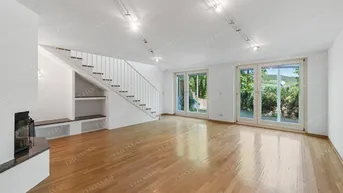 Helles Wohnzimmer mit Parkettboden, Kamin und großen Fenstern mit Blick ins Grüne.