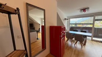 Heller offener Wohn- und Essbereich mit Holzboden, großem Spiegel und Zugang zum Balkon.