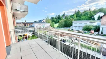 Geräumiger Balkon mit Fliesenboden und Blick auf die grüne Umgebung und angrenzende Gebäude.