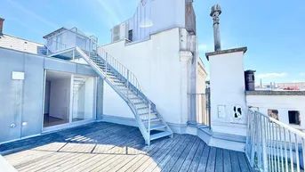 Große Dachterrasse mit Holzbelag und einer Außentreppe, die zu einem weiteren Bereich führt.